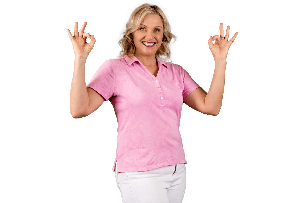 Paula Nutting, a Remedial Massage Therapist, wearing a pink blouse and white pants smiling with two okay hand signs pose