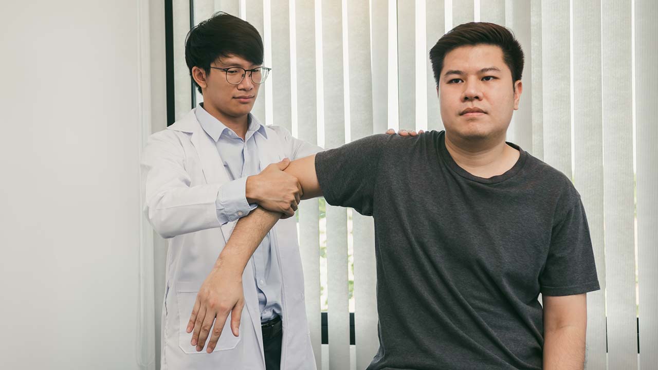 guy doctor stretching his client's arm outwards